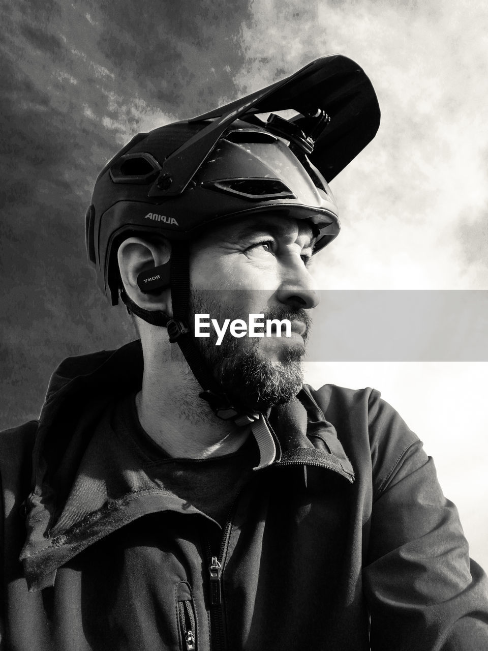 black, adult, men, monochrome, black and white, one person, monochrome photography, beard, facial hair, clothing, portrait, person, sky, cloud, helmet, headwear, headshot, glasses, looking, looking away, human face, serious, nature, cap, mature adult, outdoors