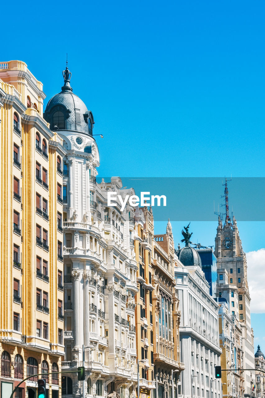 LOW ANGLE VIEW OF BUILDINGS IN CITY AGAINST CLEAR SKY