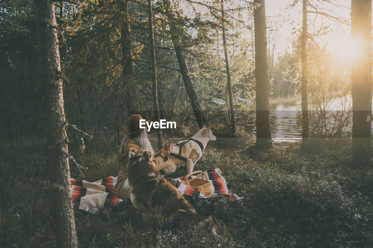 Woman with dog relaxing at lake