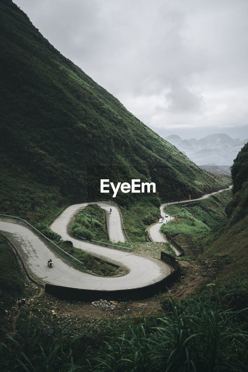 Scenic view of winding road on mountain against sky