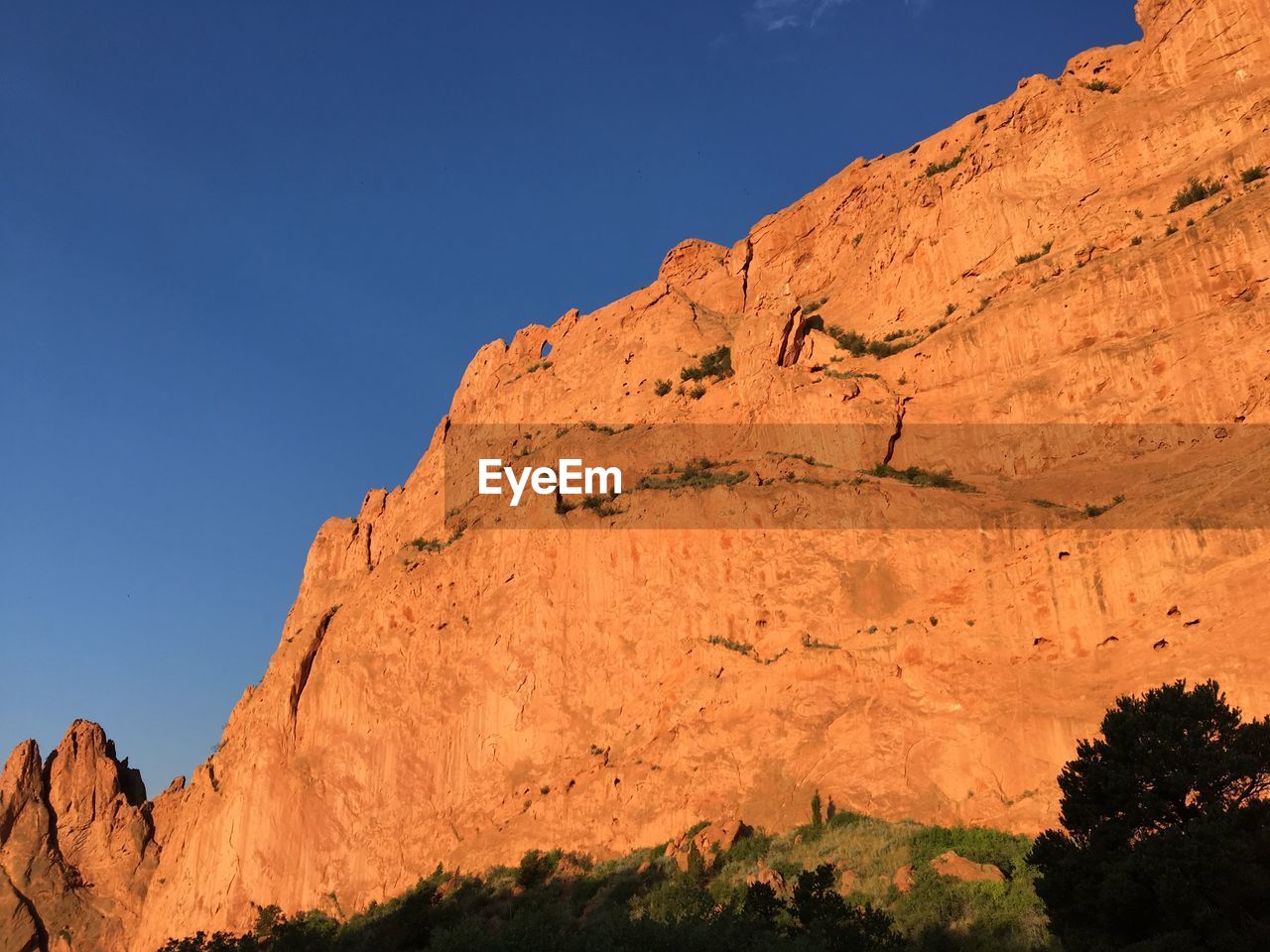 LOW ANGLE VIEW OF ROCKY MOUNTAIN AGAINST CLEAR SKY