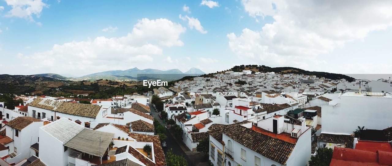 HIGH ANGLE VIEW OF TOWNSCAPE AGAINST CLOUDY SKY