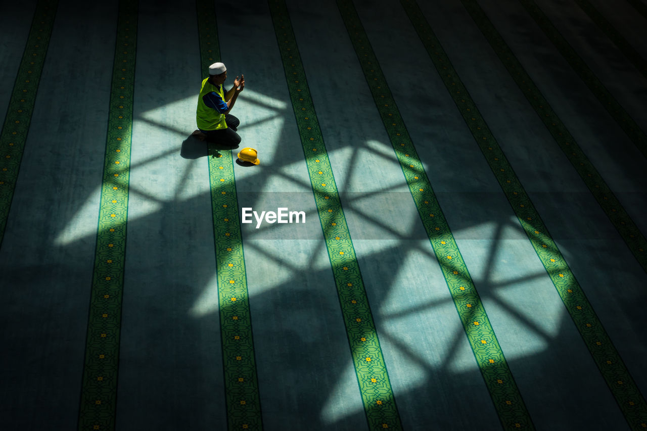 High angle view of man praying in mosque