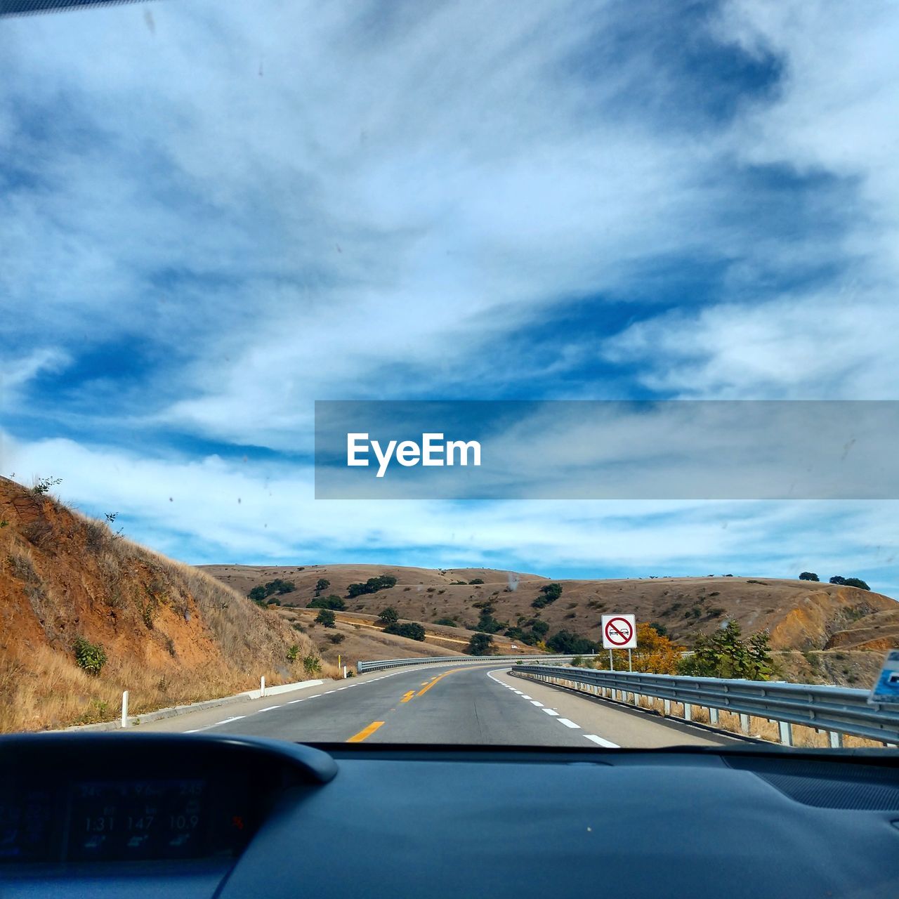 ROAD SEEN THROUGH WINDSHIELD OF CAR