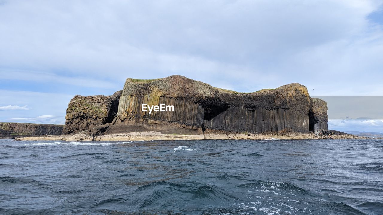 rocks in sea against sky