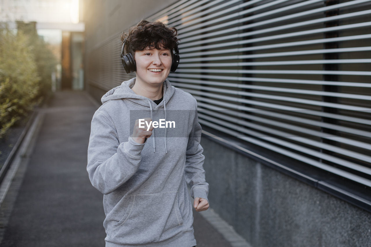 PORTRAIT OF SMILING MAN STANDING OUTDOORS