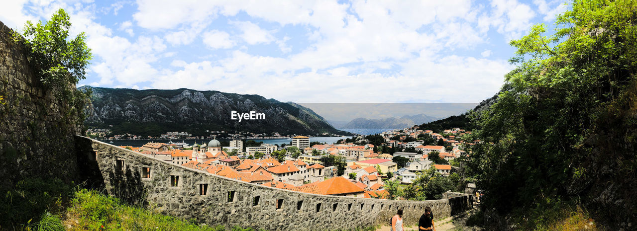 PANORAMIC VIEW OF TOWN AGAINST CLOUDY SKY