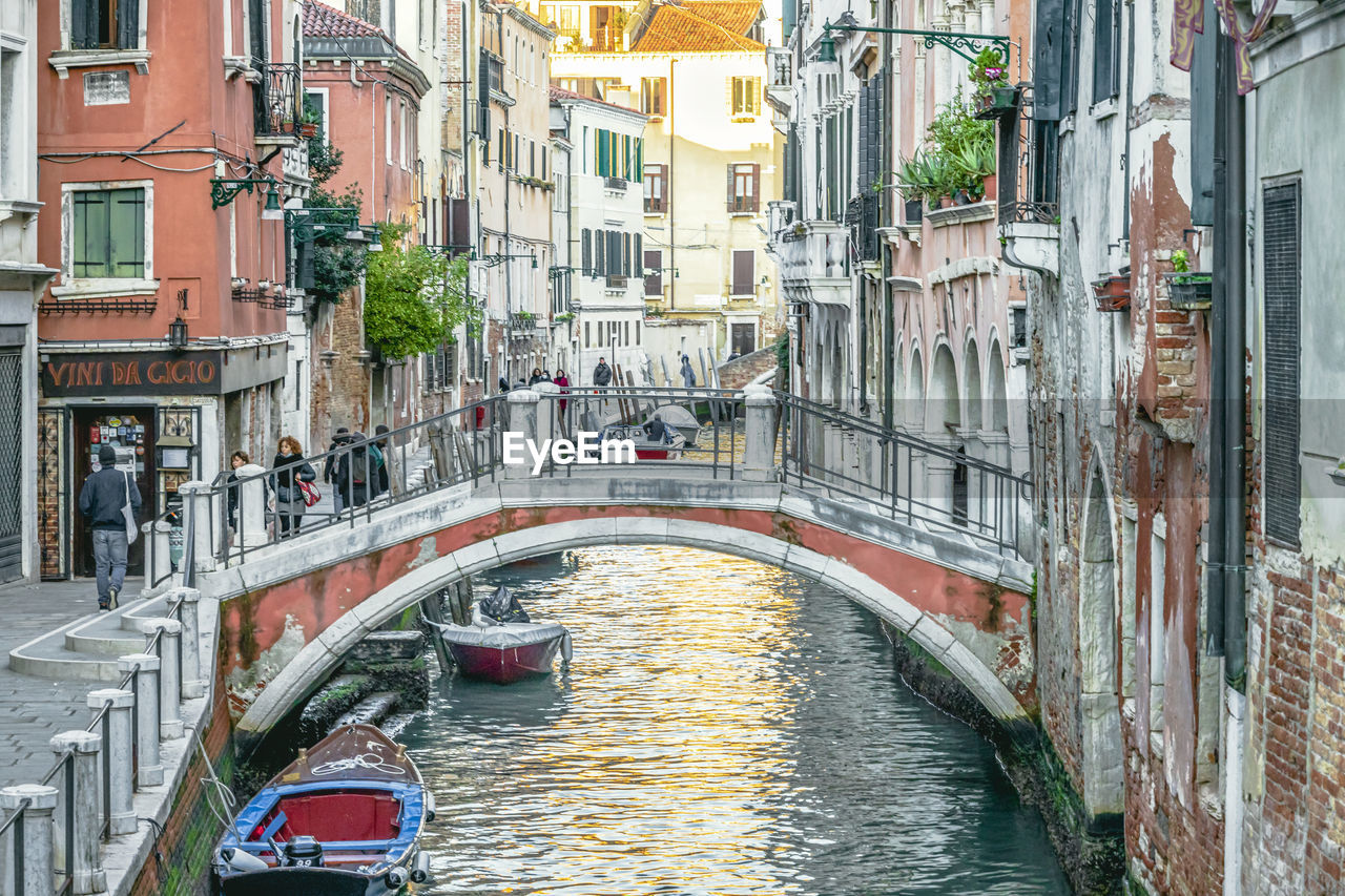 architecture, canal, built structure, building exterior, transportation, water, bridge, nautical vessel, city, mode of transportation, waterway, travel destinations, boat, gondola, travel, tourism, channel, body of water, nature, building, vehicle, town, watercraft, day, cityscape, gondolier, residential district, footbridge, waterfront, outdoors, street, tourist, holiday, trip, vacation, city life, arch, craft