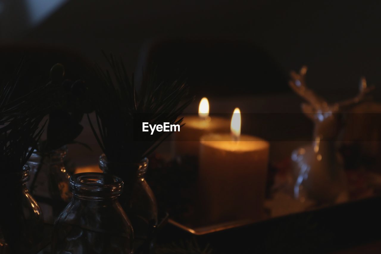 CLOSE-UP OF BURNING CANDLE IN GLASS