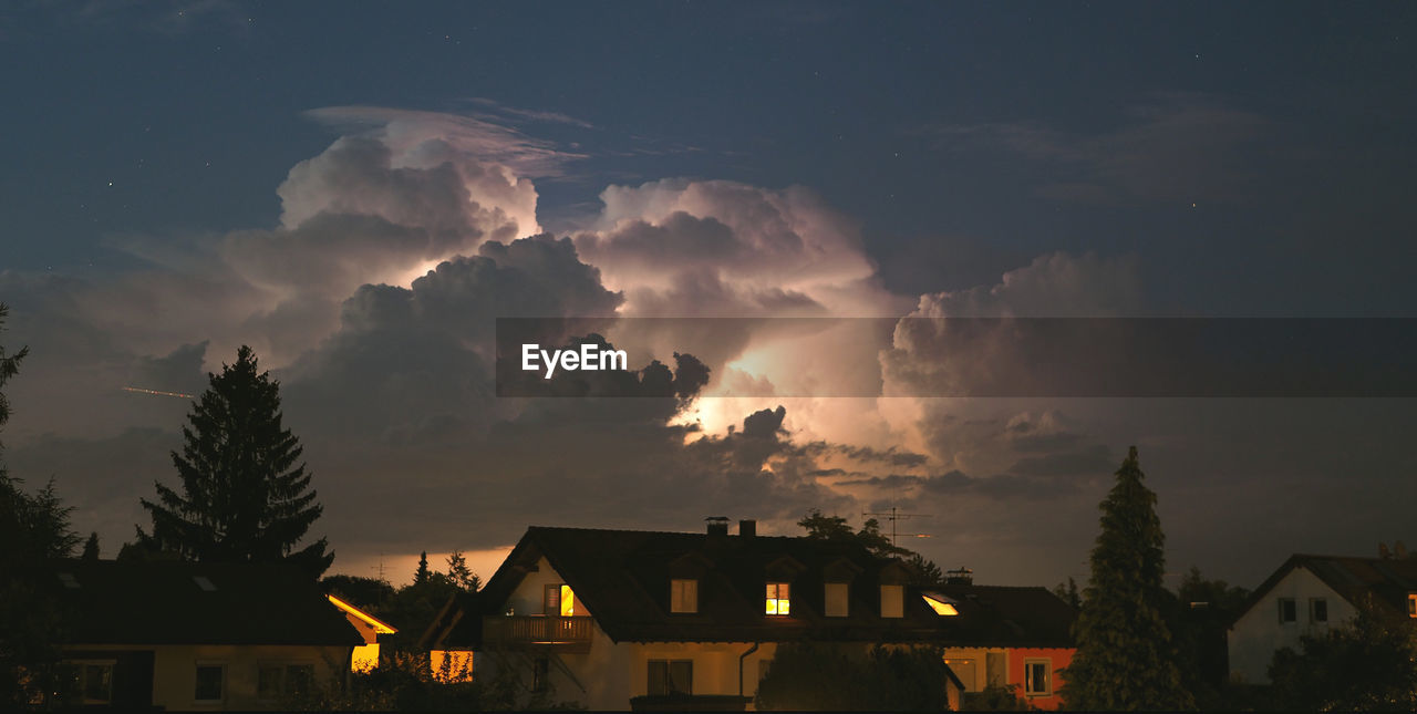 VIEW OF HOUSES AGAINST CLOUDY SKY