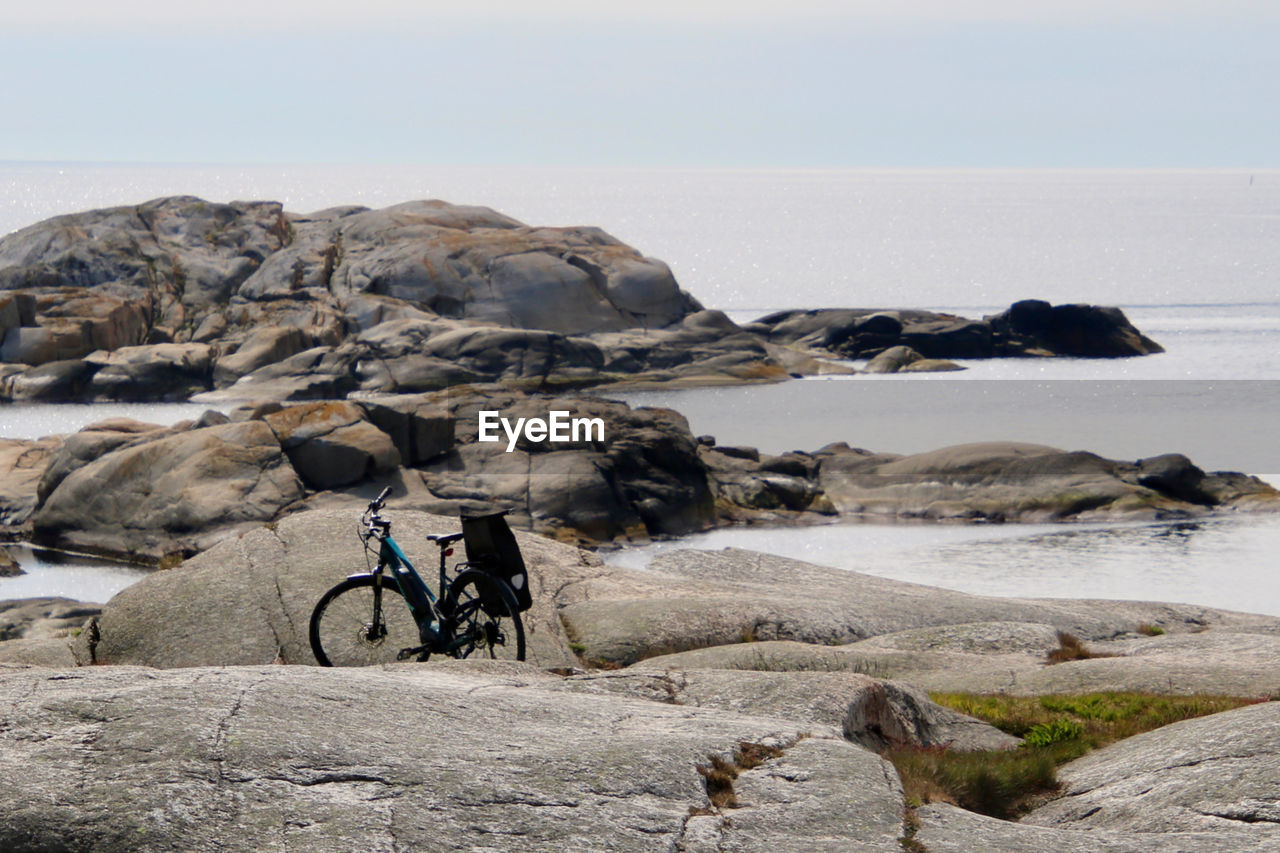 BICYCLE ON ROCKS BY SEA