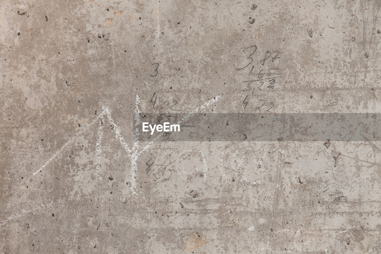 FULL FRAME SHOT OF CONCRETE WALL WITH WEATHERED FLOOR