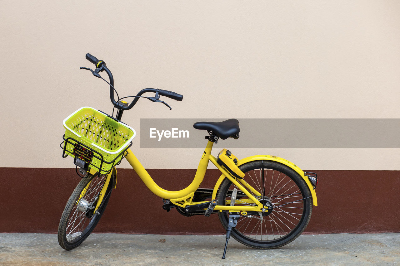 A yellow bicycle parked next to the house leave space for the text.