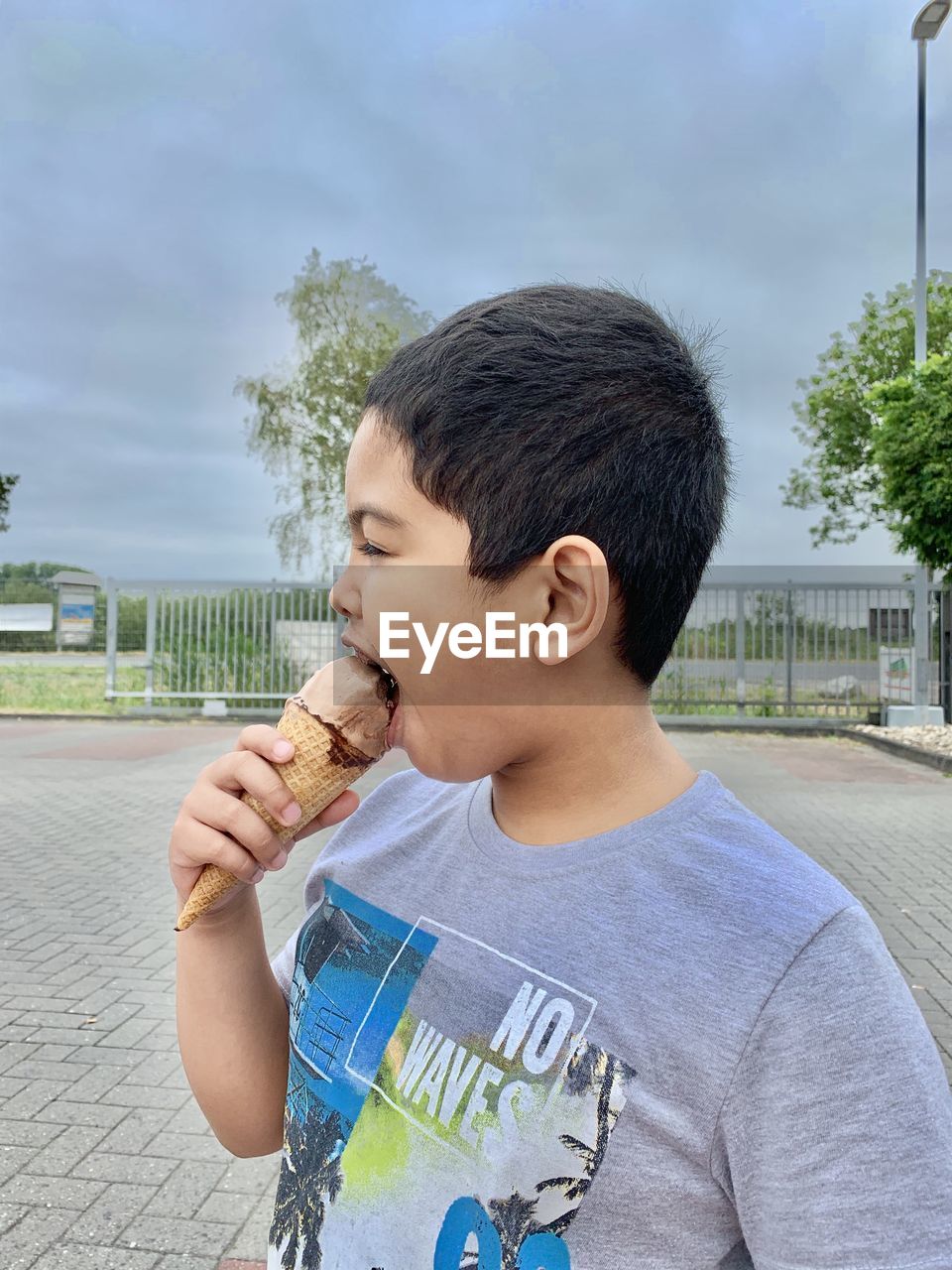 Side view of boy eating ice cream cone