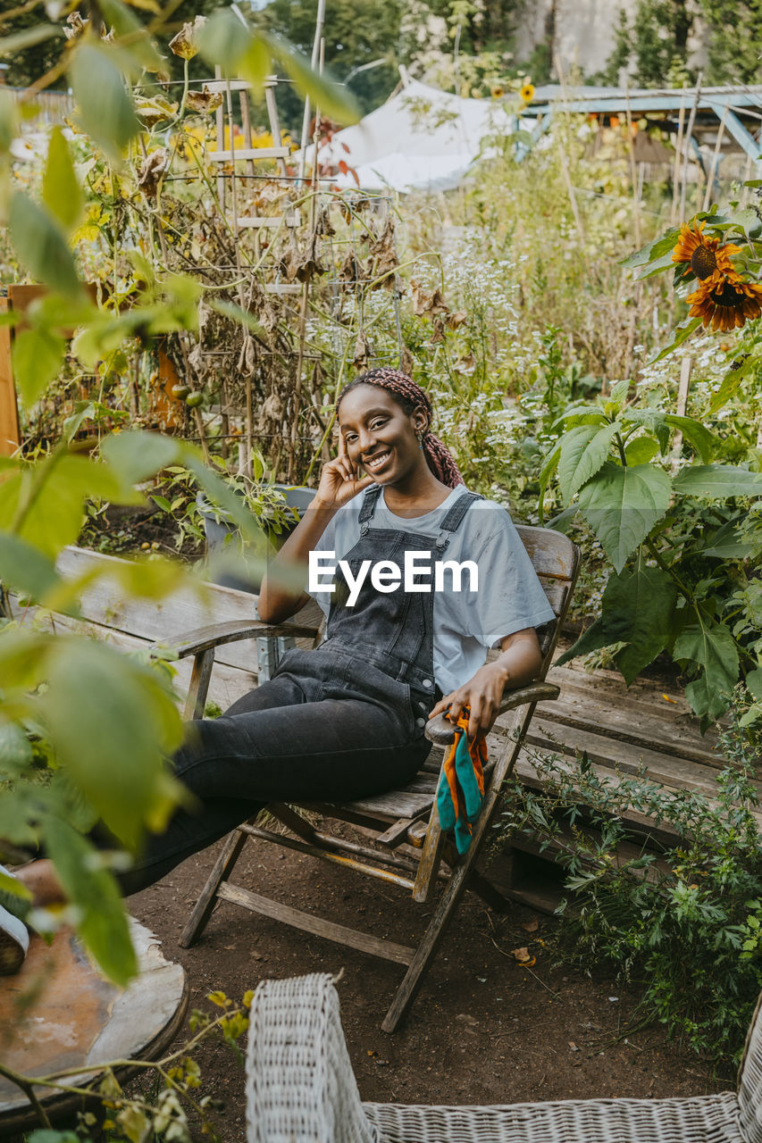 Portrait of female farmer sitting on chair in organic farm