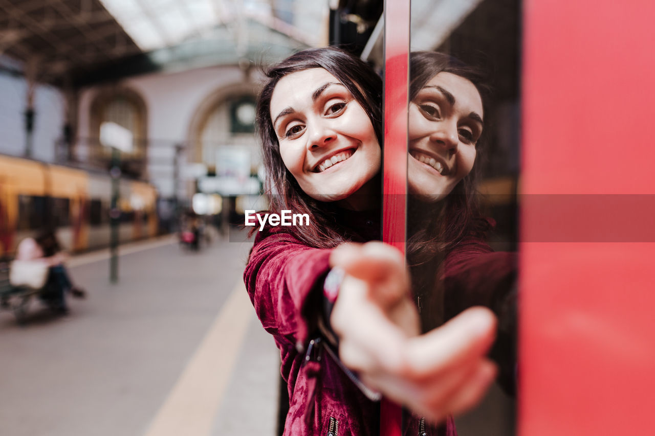 Portrait of smiling woman standing in subway train