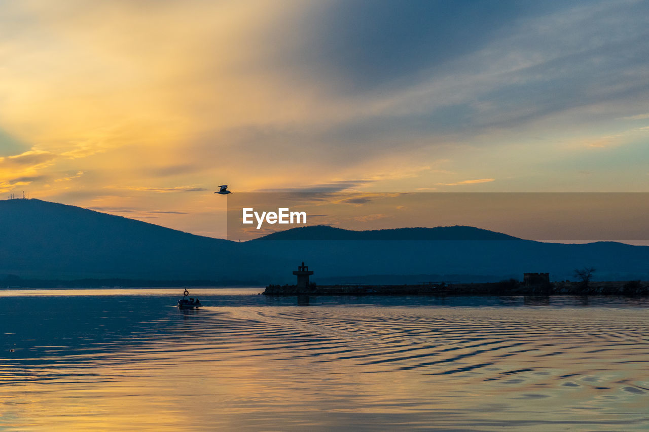 SCENIC VIEW OF LAKE AGAINST ORANGE SKY