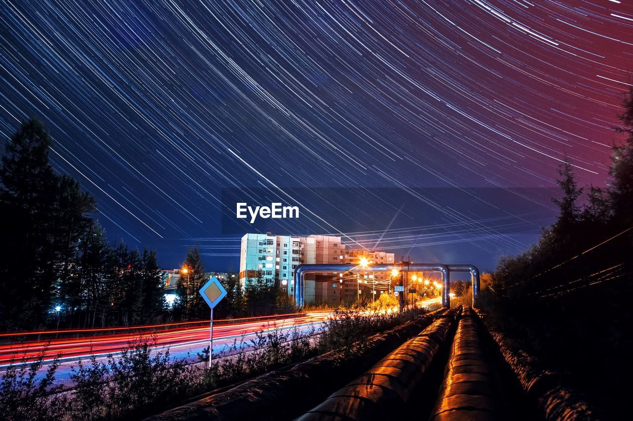 Illuminated railroad tracks against sky at night