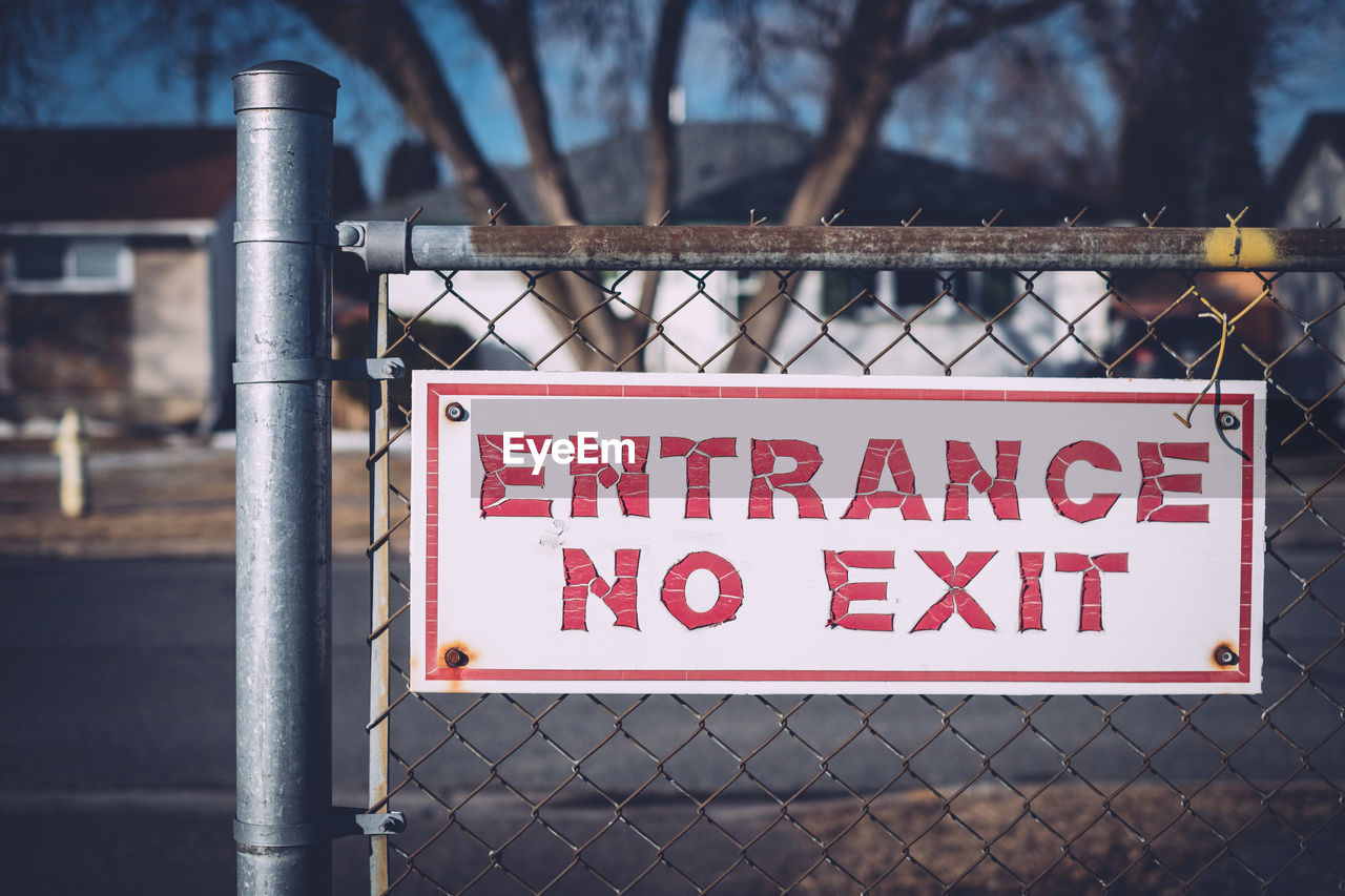 Close-up of warning sign on chainlink fence