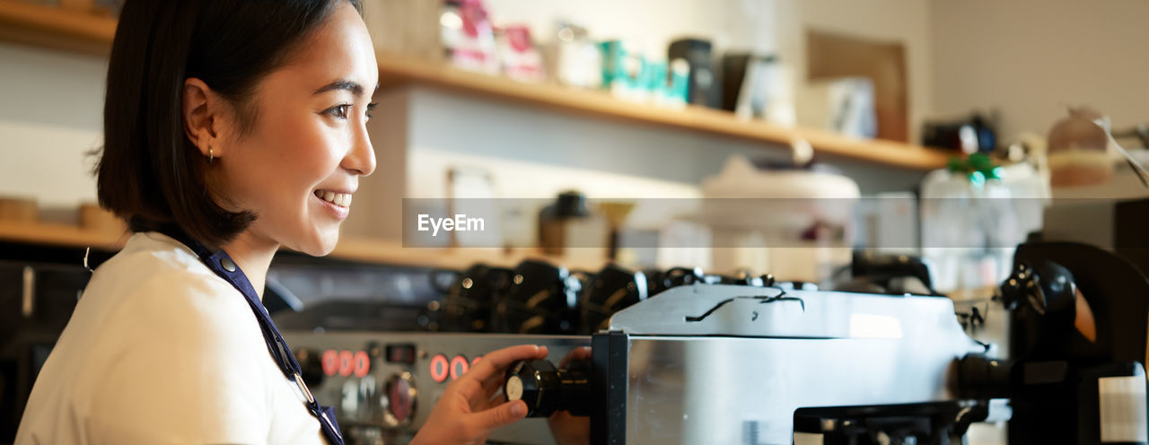 side view of young woman looking at coffee