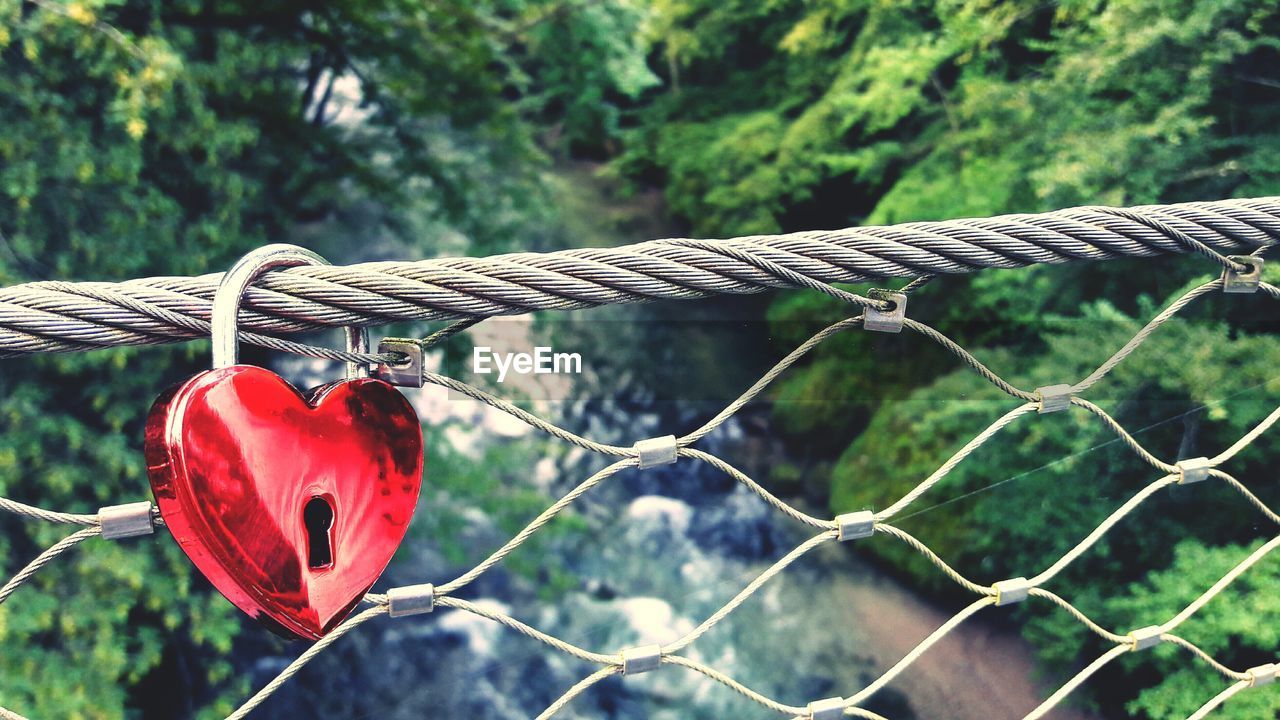 High angle view of red heart shape love lock on bridge over river