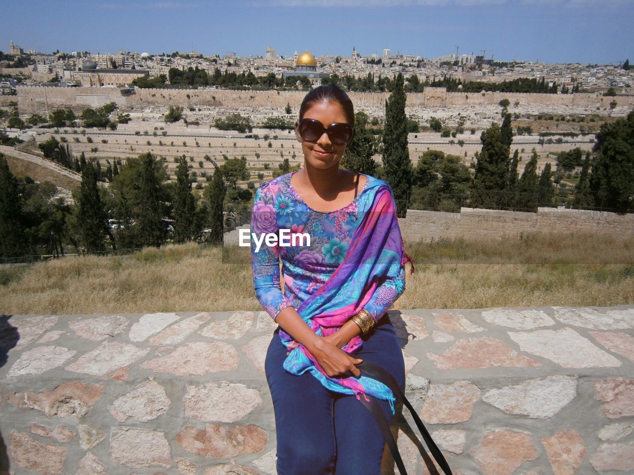 Portrait of woman wearing sunglasses sitting outdoors