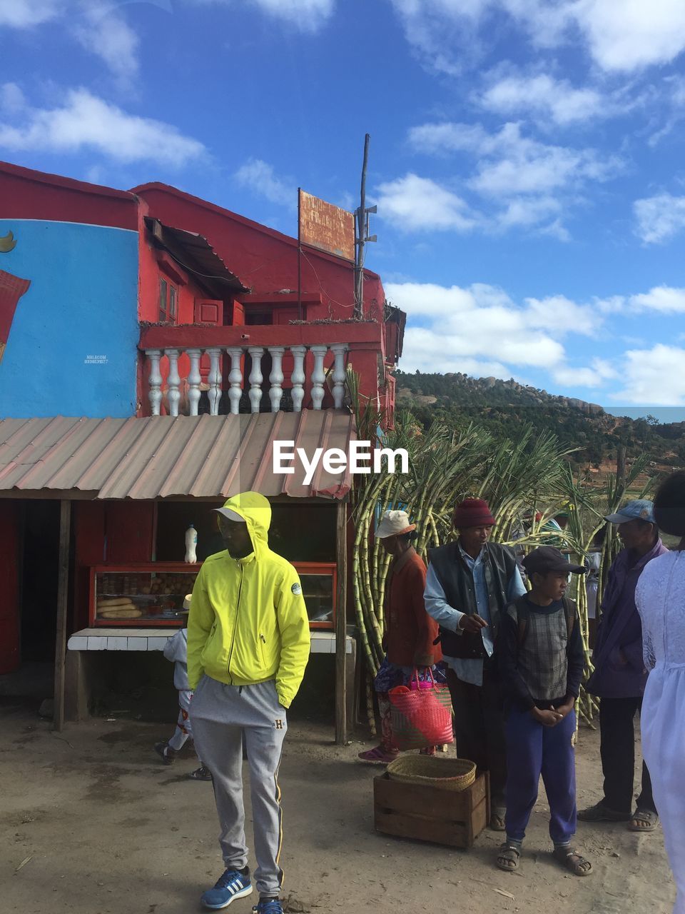 REAR VIEW OF PEOPLE STANDING OUTSIDE BUILDING