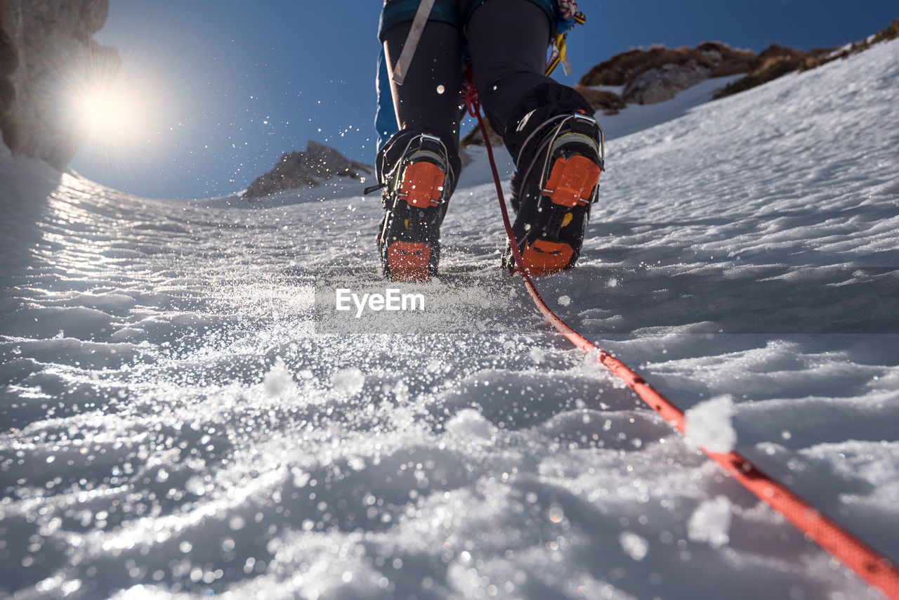 Low section of person skiing on snowcapped mountain
