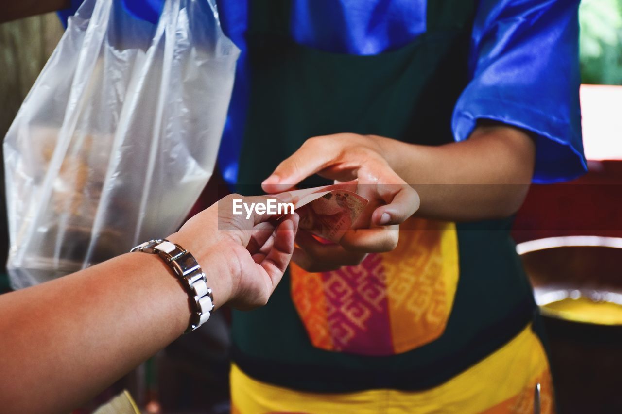 Person buying from market vendor