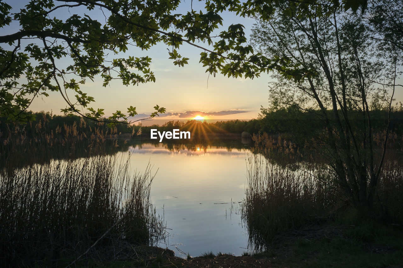 Scenic view of lake against sky at sunset