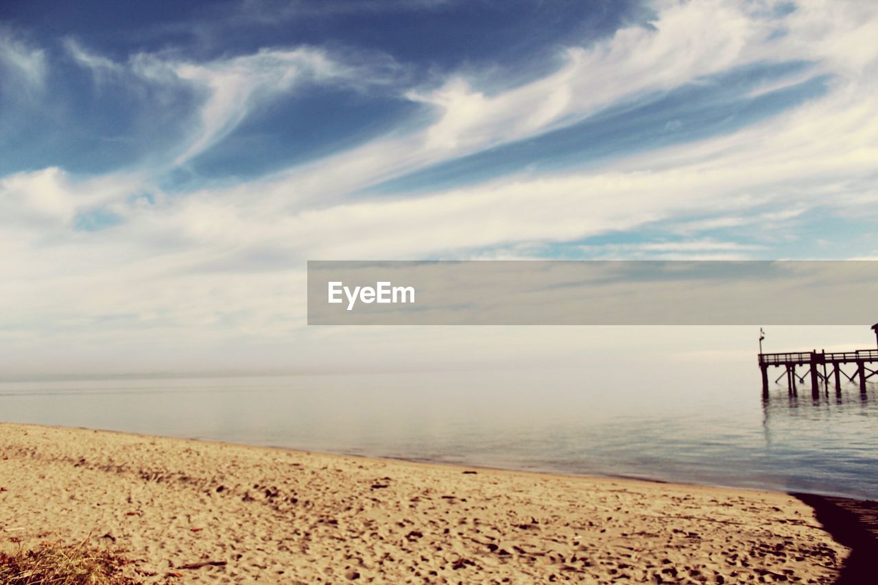 Scenic view of beach and sea against cloudy sky