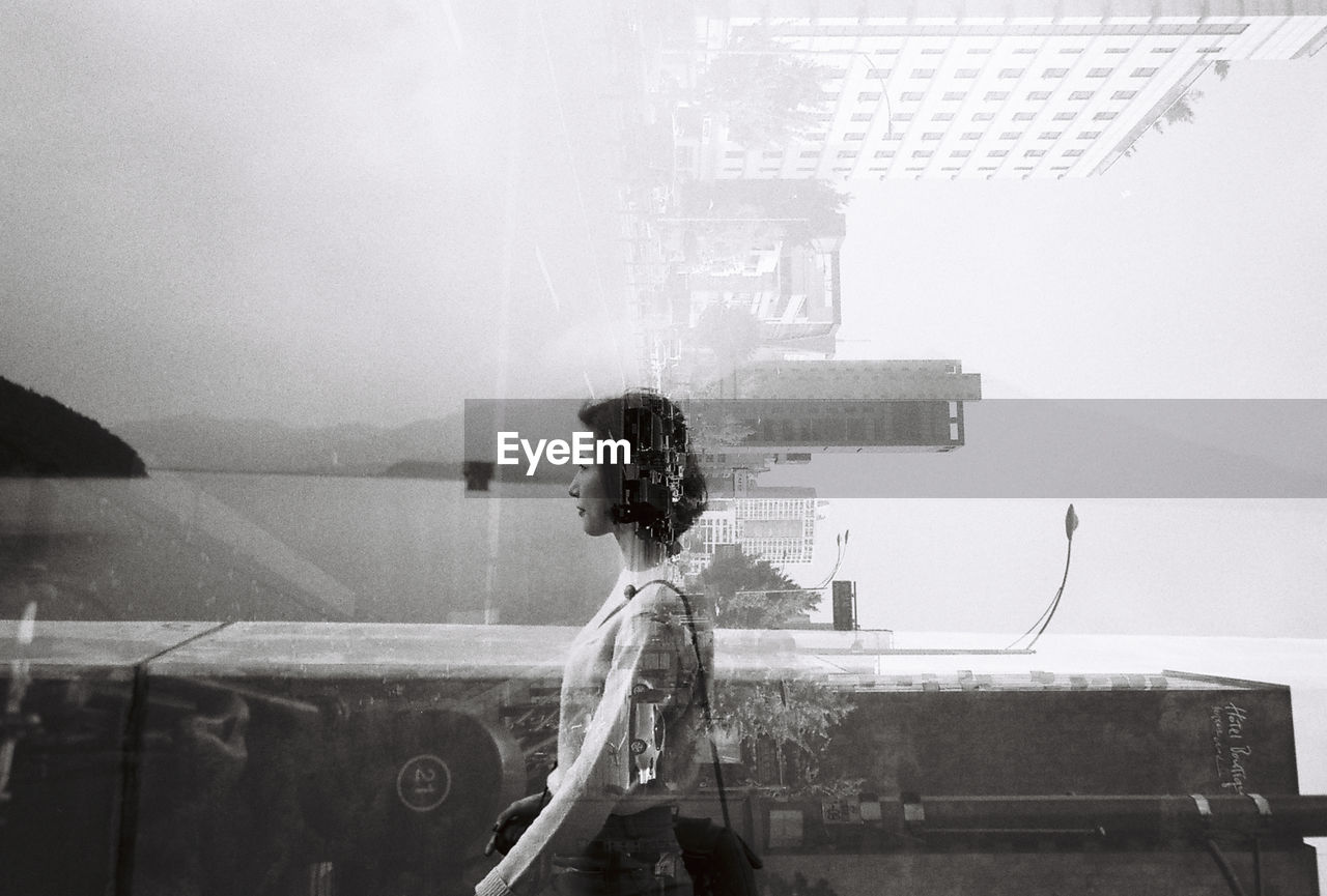 Double exposure of young woman and buildings