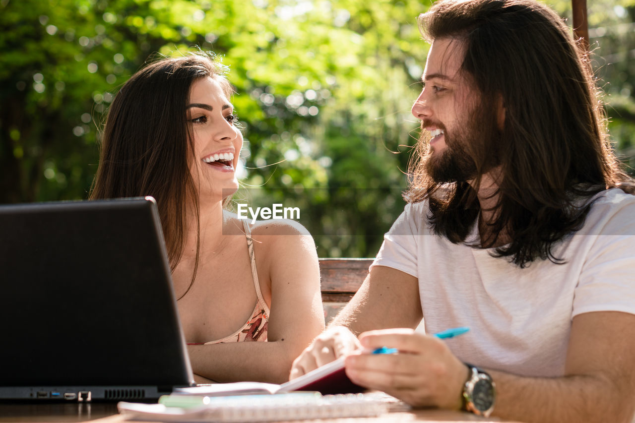 side view of woman using laptop while sitting at office