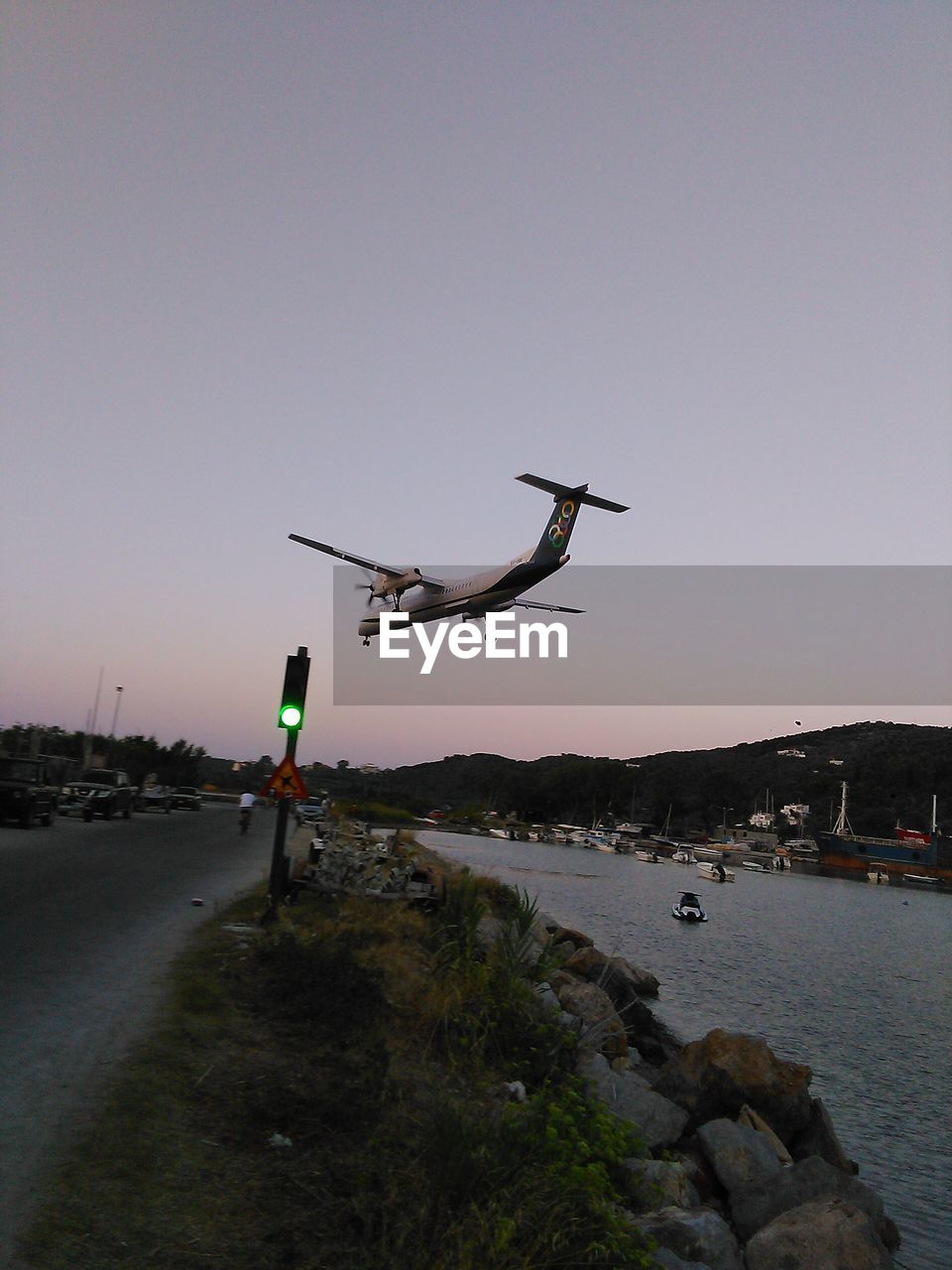 AIRPLANE FLYING OVER BEACH AGAINST CLEAR SKY