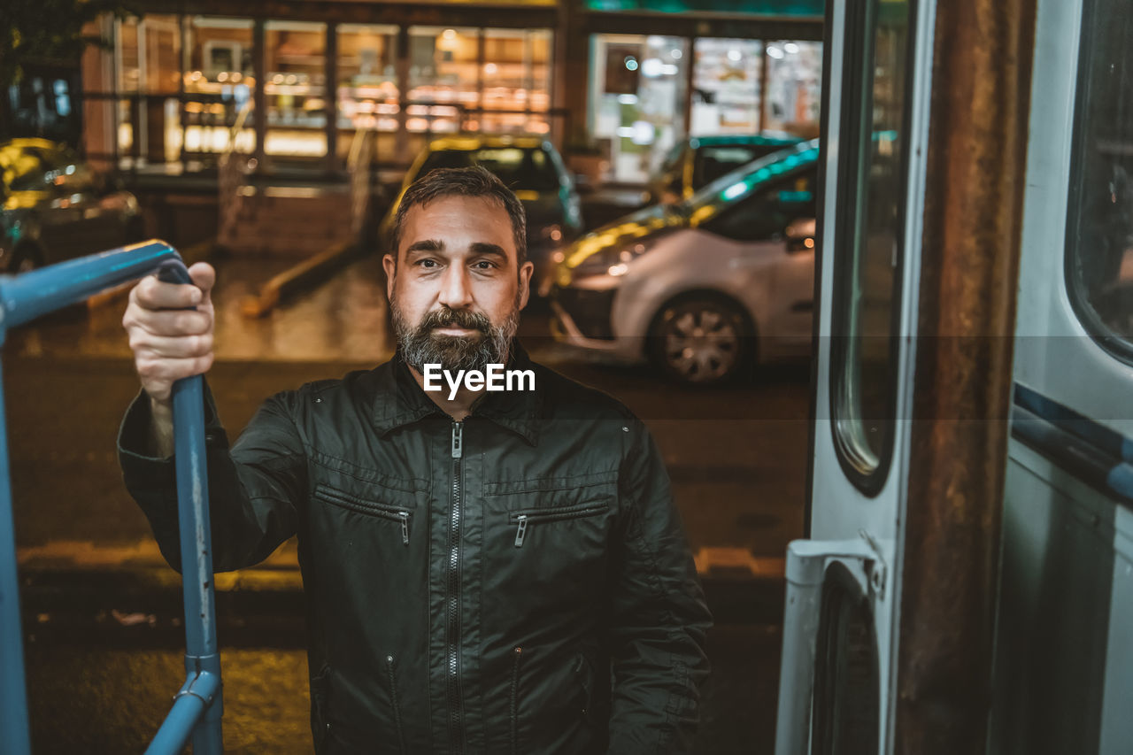 Handsome bearded man enters the tram or public transport. man on a bus/tram stop.