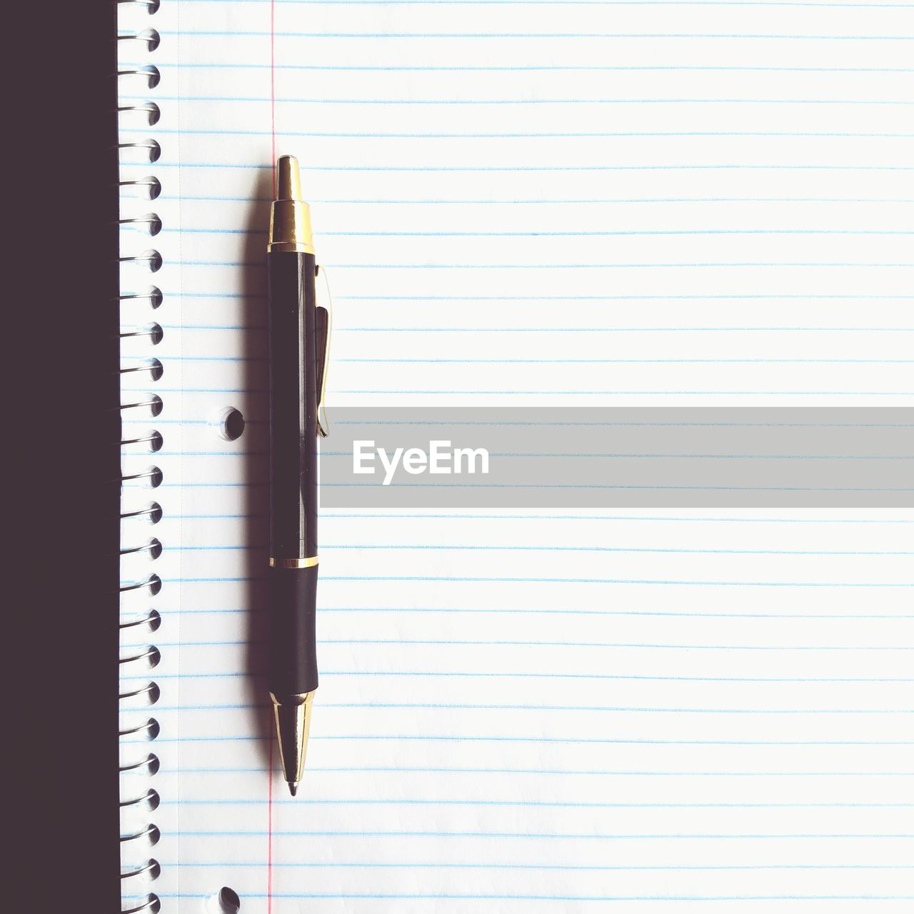 Directly above shot of pen on spiral notebook at table