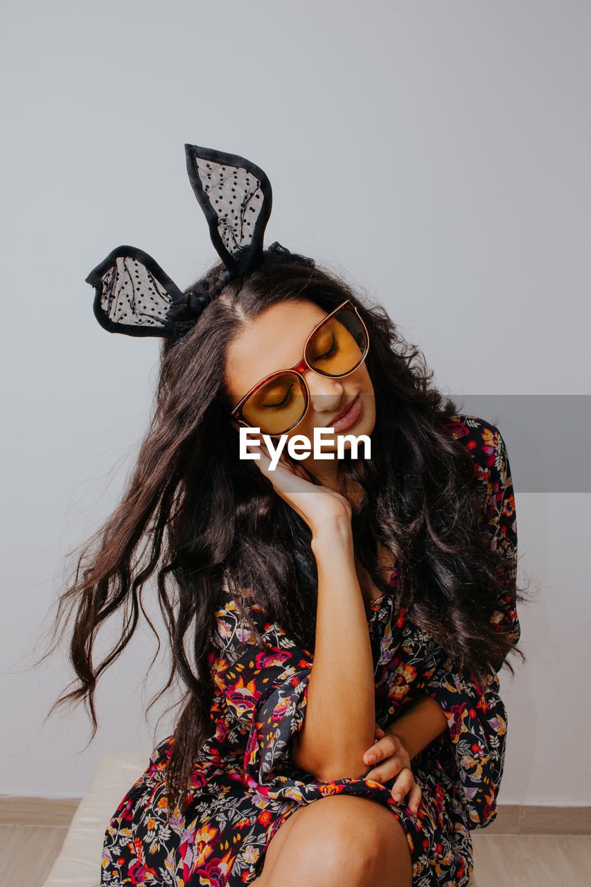 Close up portrait of pretty girl with bunny ears and vintage sunglasses. place for text.