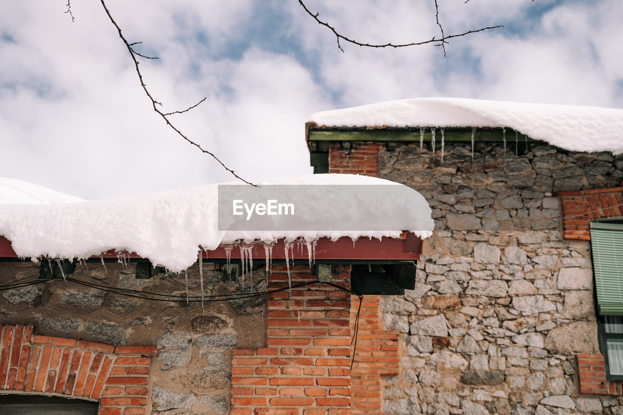 HOUSES ON SNOW COVERED ROOF AGAINST BUILDINGS
