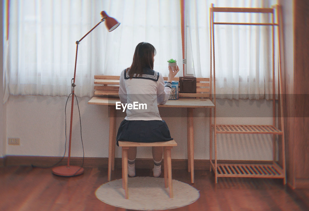 Rear view of woman sitting on chair