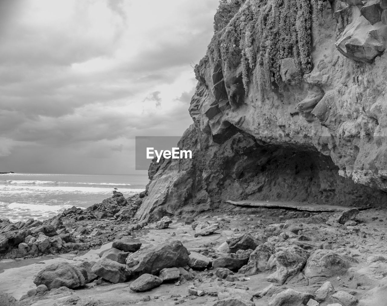 Rock formation on beach against sky