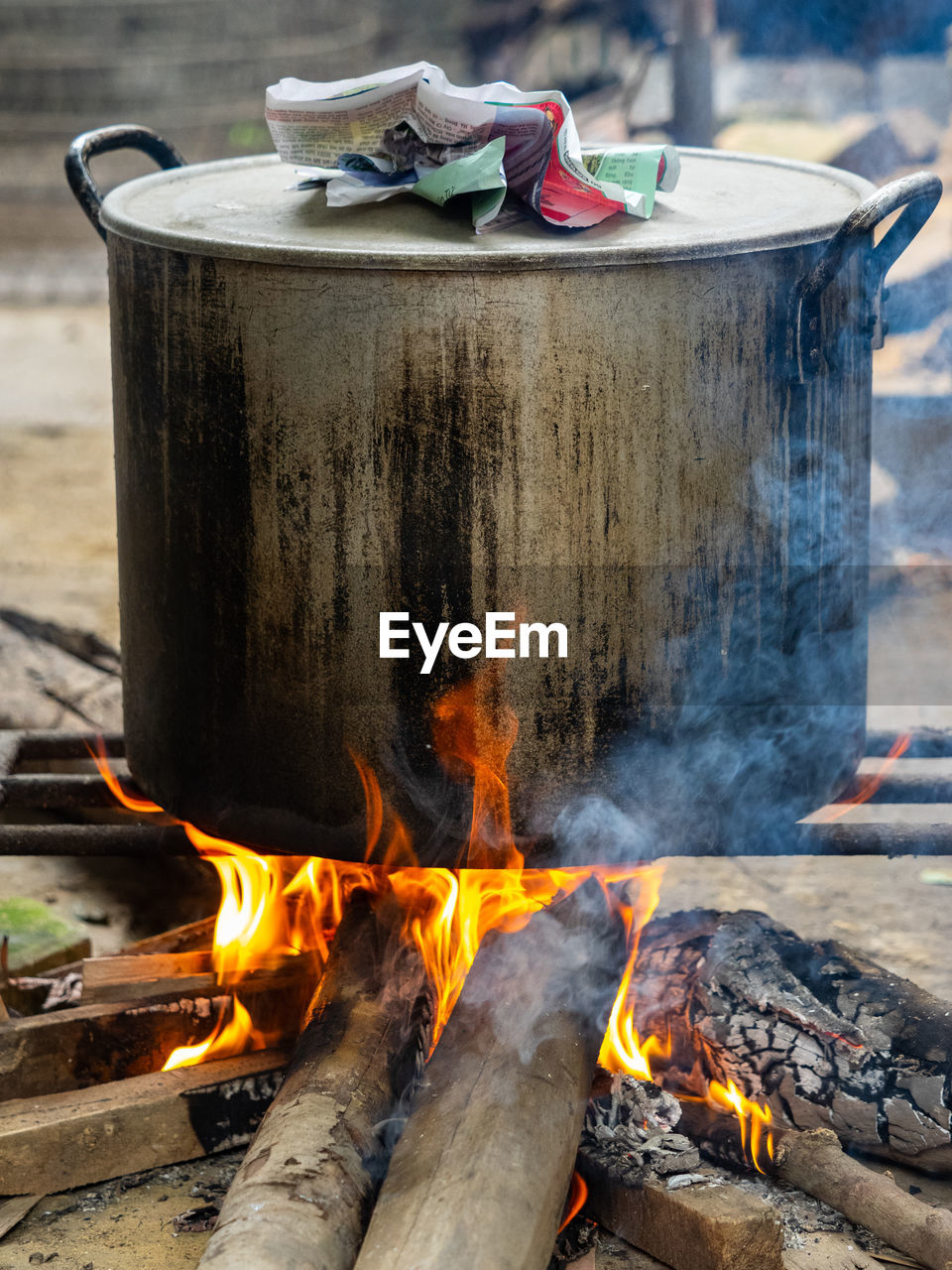 Steel pot on an open fire with firewood