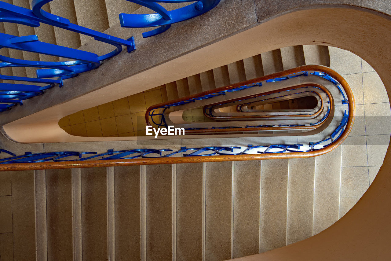 staircase, steps and staircases, railing, architecture, spiral staircase, spiral, stairs, built structure, indoors, no people, blue, curve, high angle view