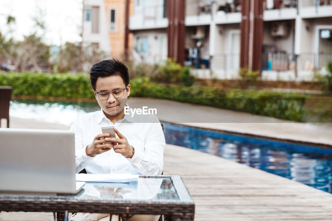 Man using mobile phone in swimming pool