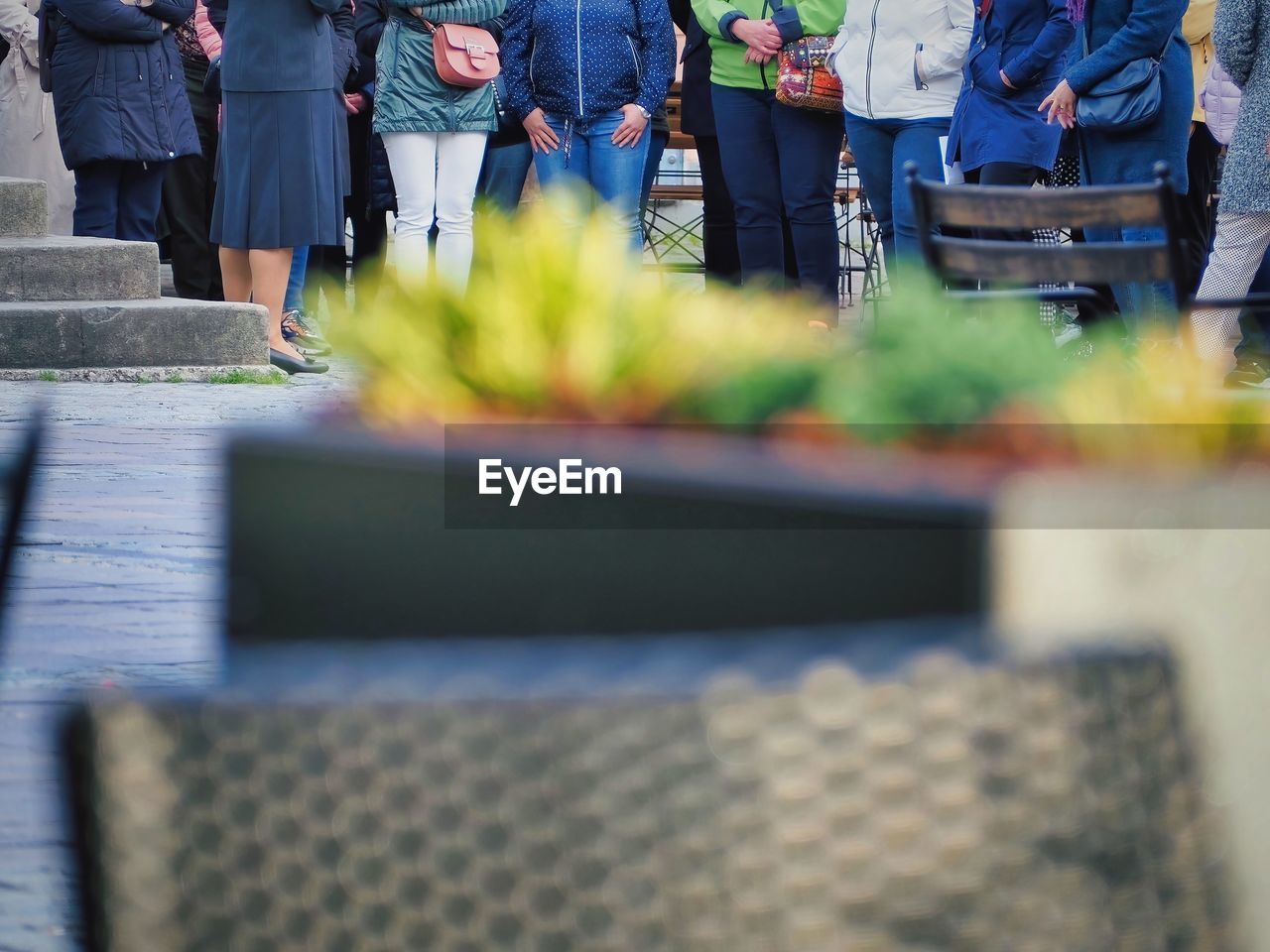 group of people, selective focus, adult, focus on background, men, women, blue, clothing, spring, crowd, day, standing, low section, outdoors, person, footwear, plant, architecture, nature, green, group, business, jeans