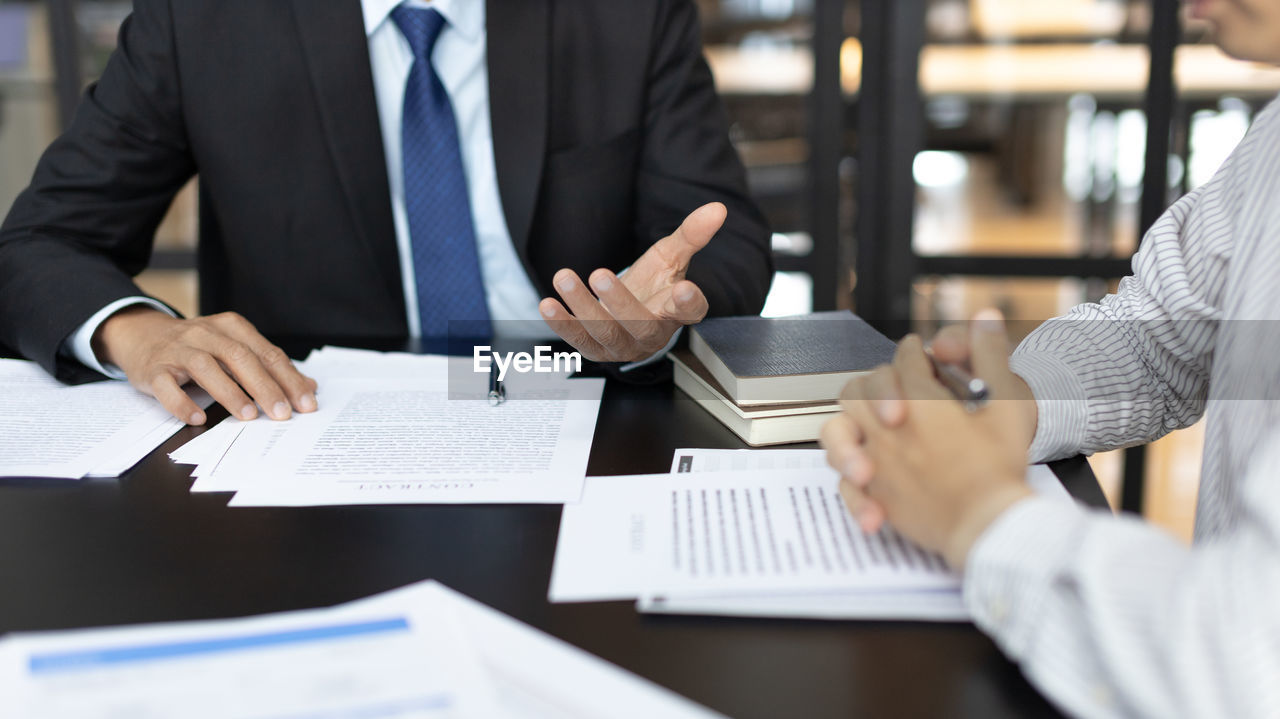 midsection of business people working on table