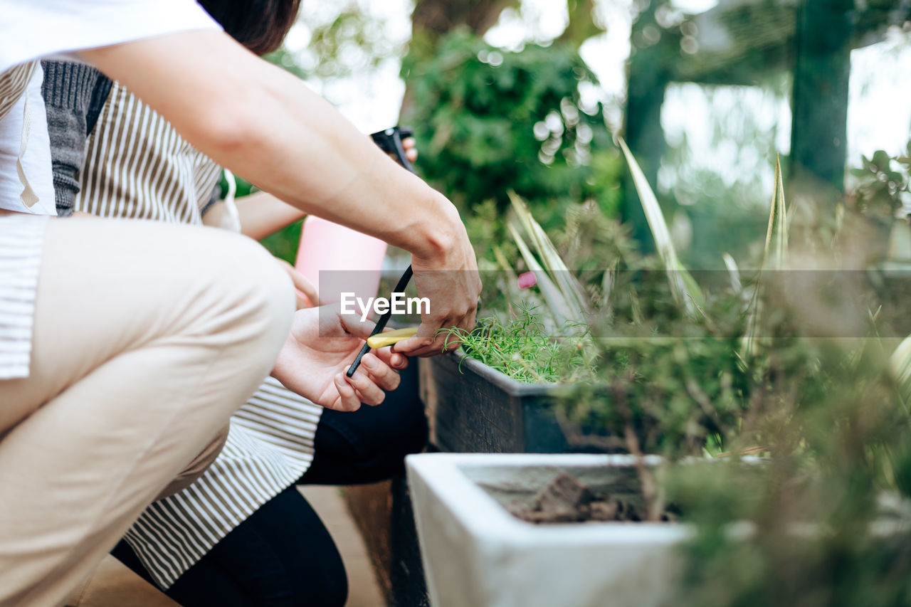 Midsection of couple watering plants