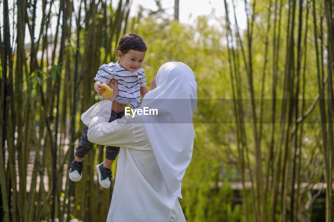 Mother with son standing outdoors