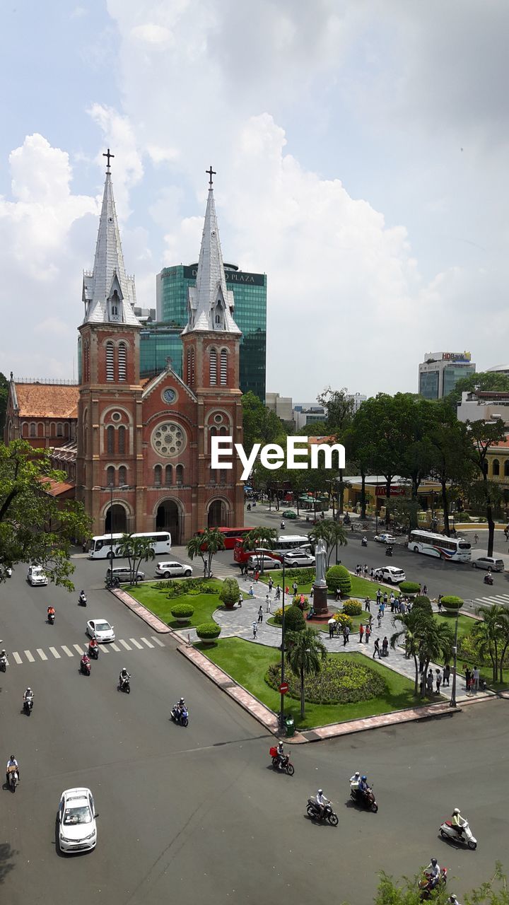 High angle view of church in city against cloudy sky