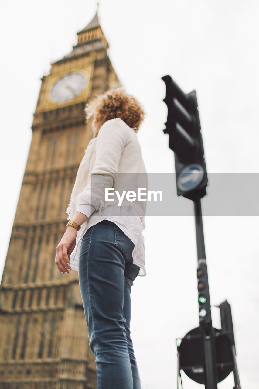 Low angle view of woman against big ben in city