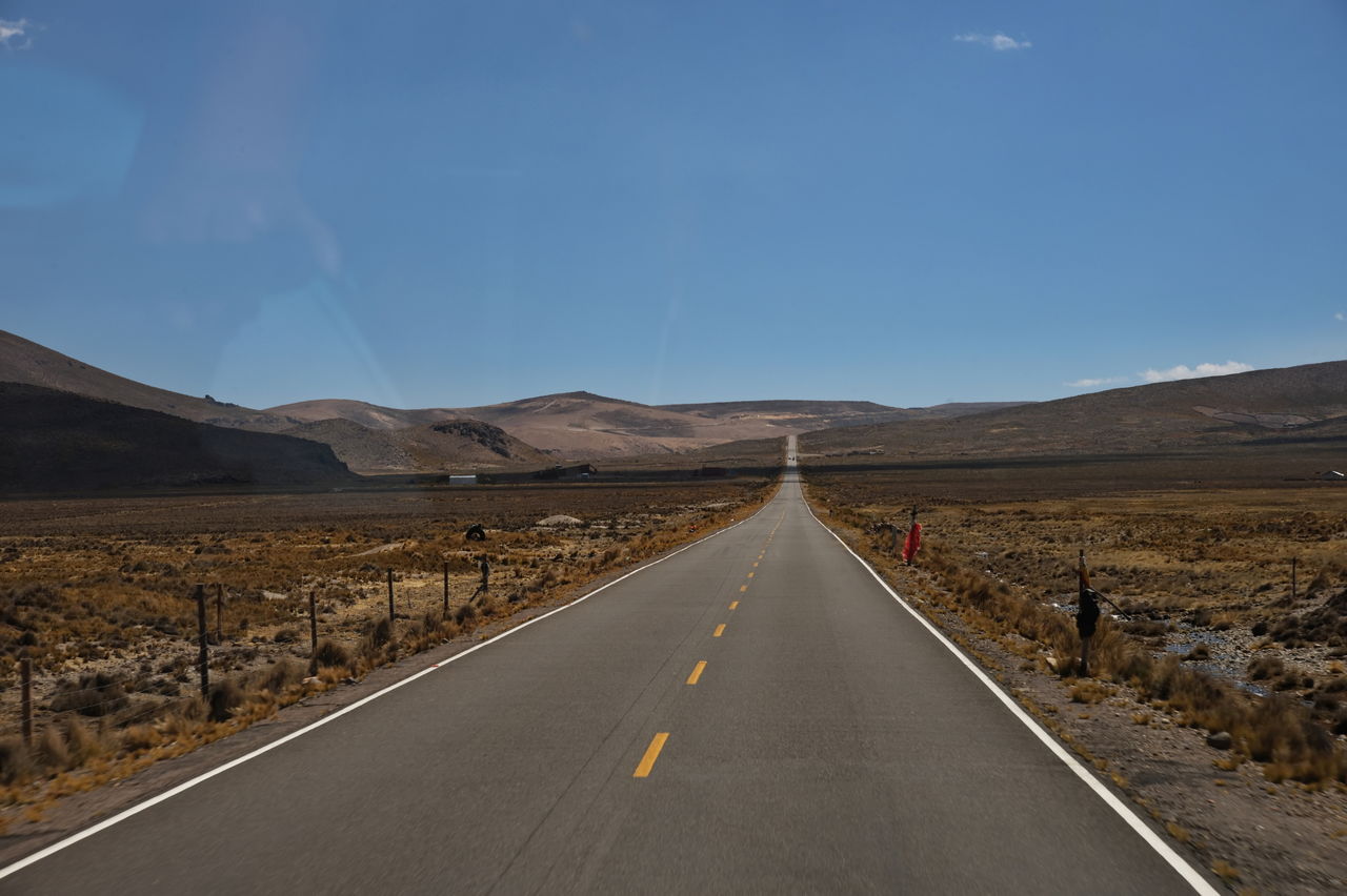 A view through the bus window of a road through the highlands of peru